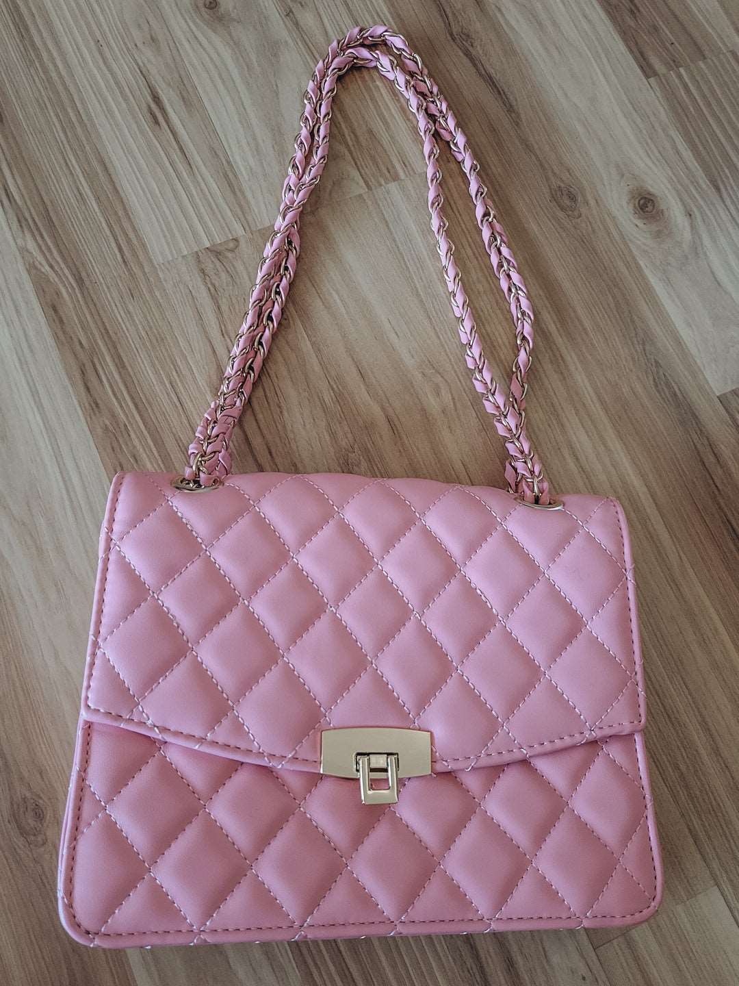 Pink quilted purse with pink and gold chain strap.