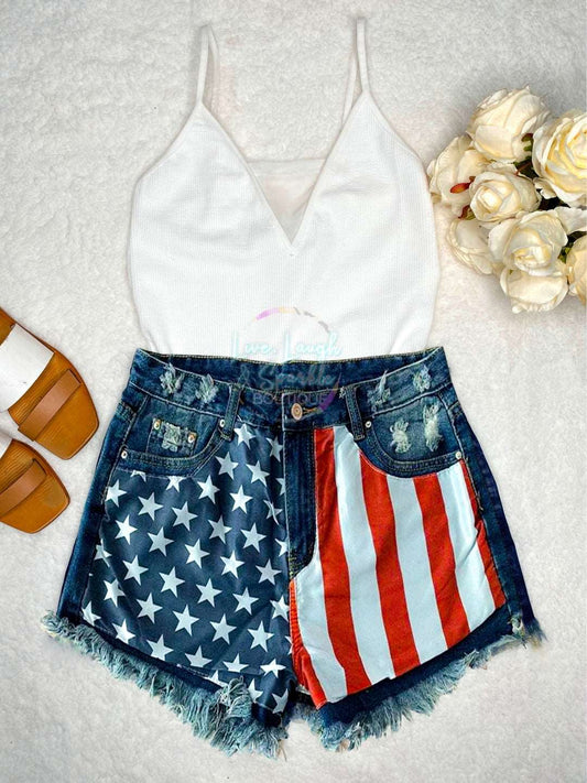 Distressed denim shorts with American flag design on the front. 