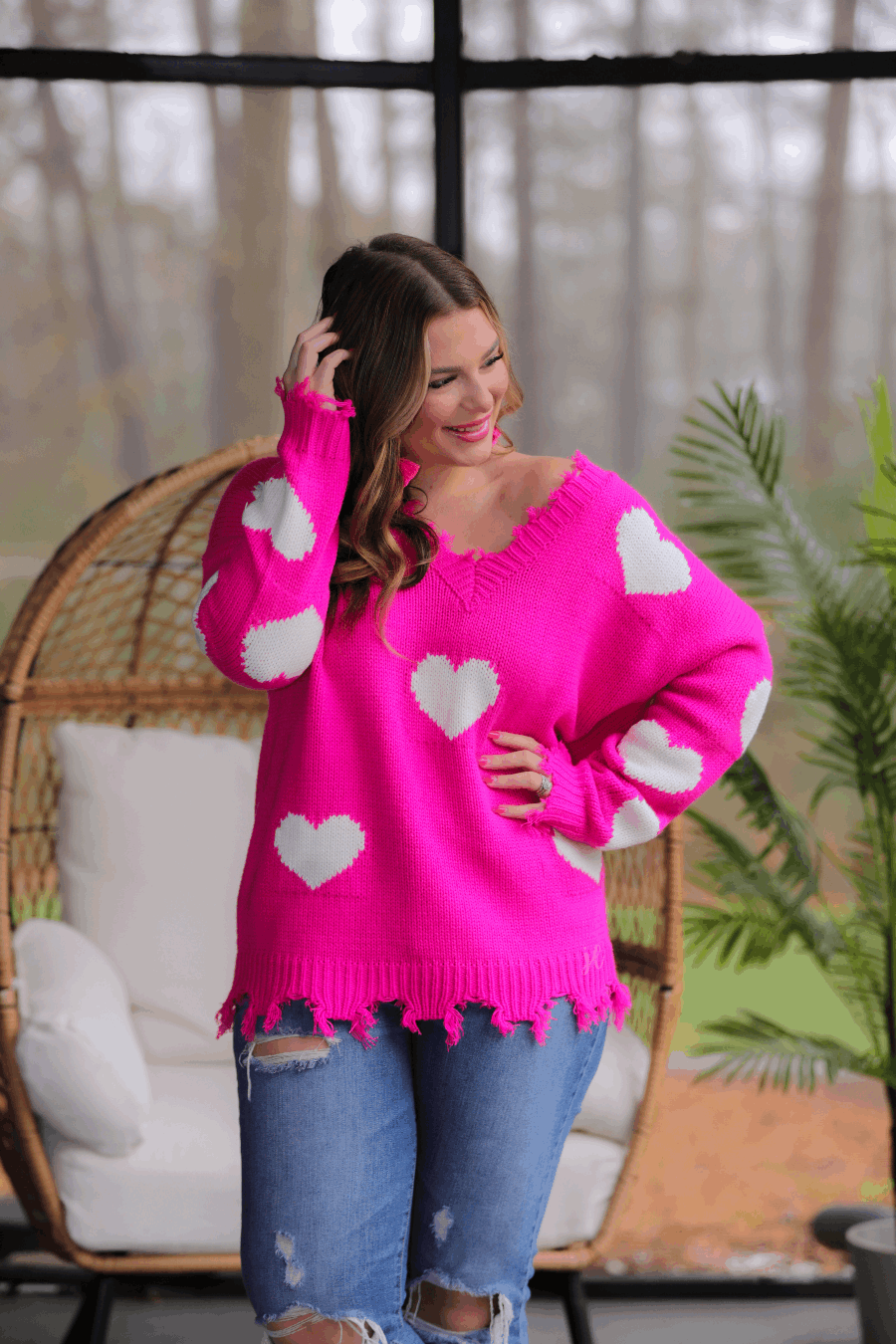 Pink distressed sweater with white hearts.