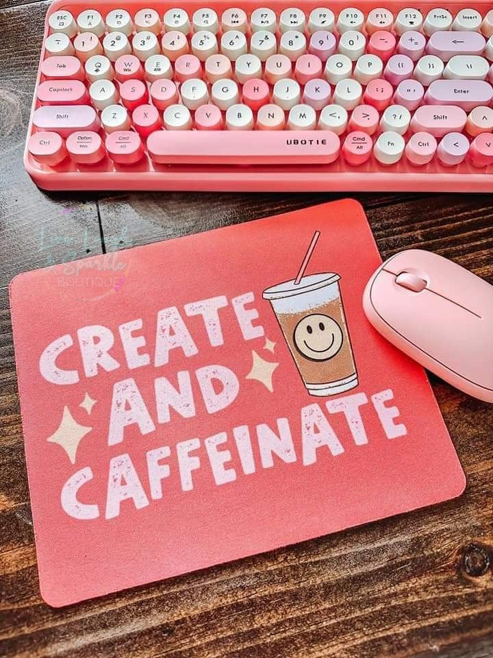 Pink mouse pad with the words create and caffeinate on it.