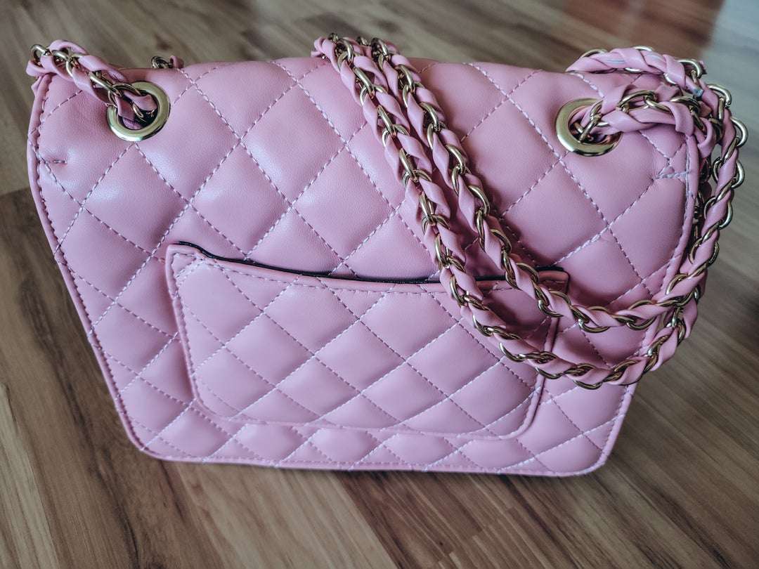 Back of bag is pink quilted with small pocket. 