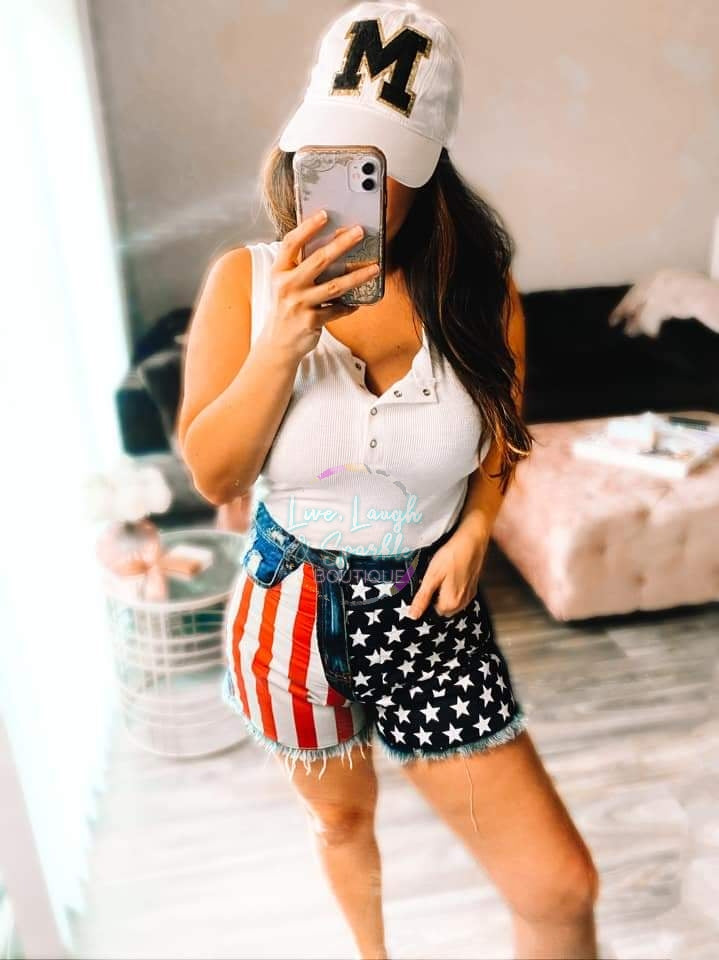 Distressed denim shorts with American flag design on the front. 