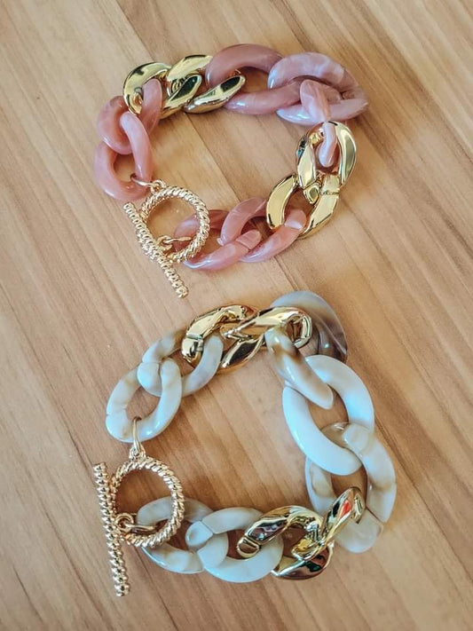 Pink and gold and white and gold chain link bracelets.