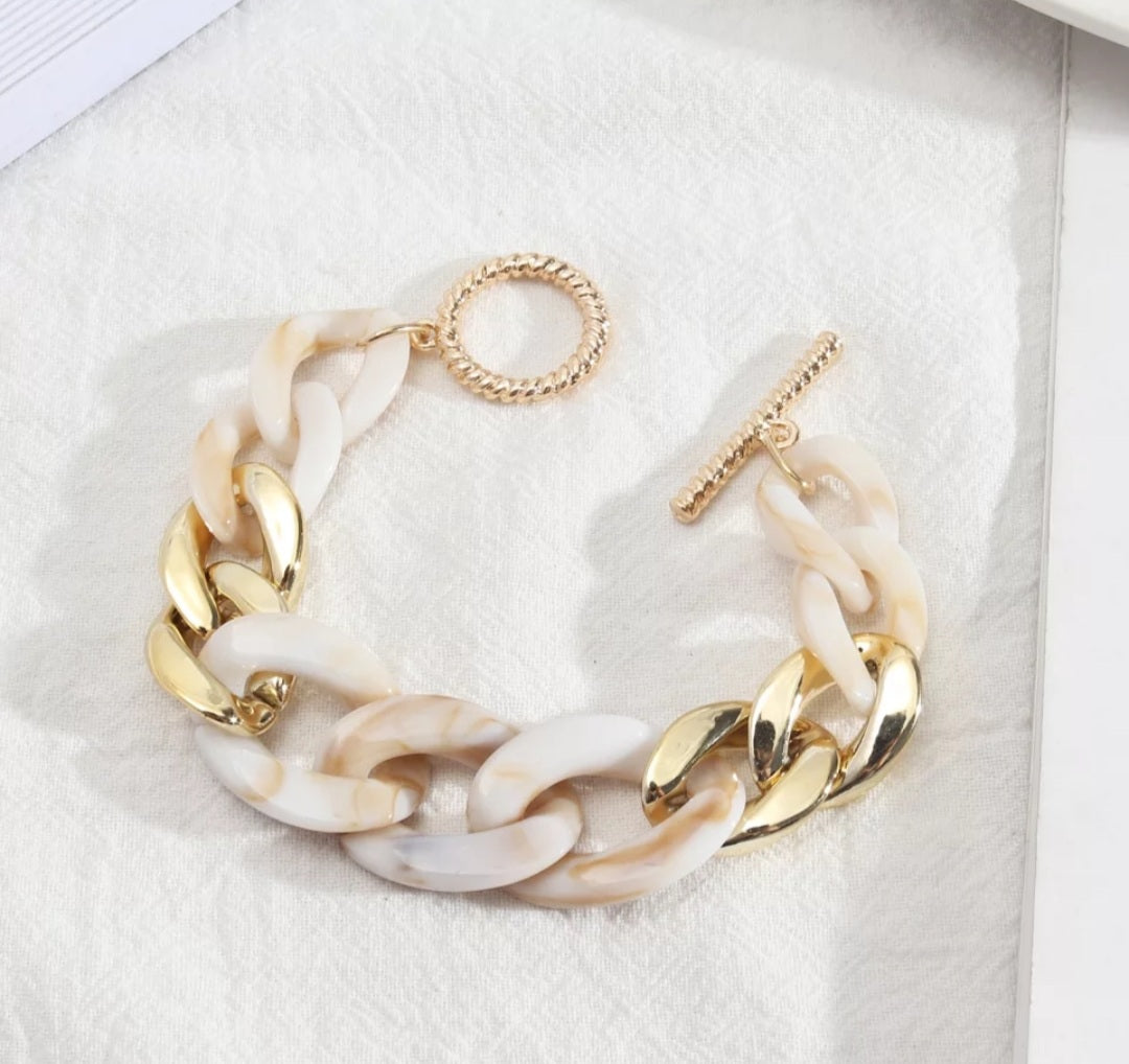 White and gold chain link bracelet.