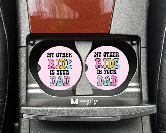 Set of pink car coasters that says my other ride is your dad. 